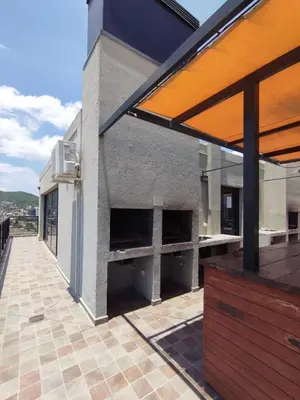 a patio with an outdoor kitchen on a building at Excelente departamento moderno con pileta in Villa Carlos Paz