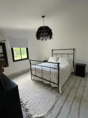 a bedroom with a bed and a chandelier at Serena in Villa de Las Rosas