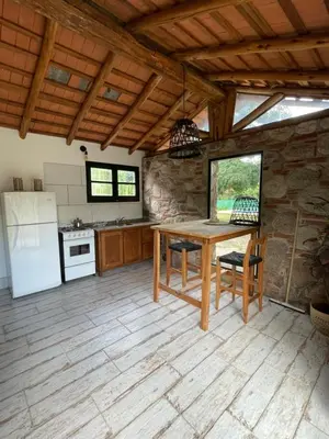 a kitchen with a wooden table and a refrigerator at Serena in Villa de Las Rosas