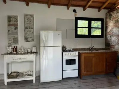 a kitchen with a white refrigerator and a stove at Serena in Villa de Las Rosas