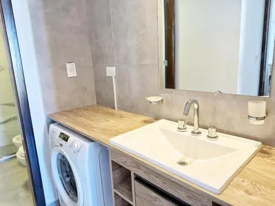 a bathroom with a sink and a washing machine at Paseo Cibeles in Villa Carlos Paz