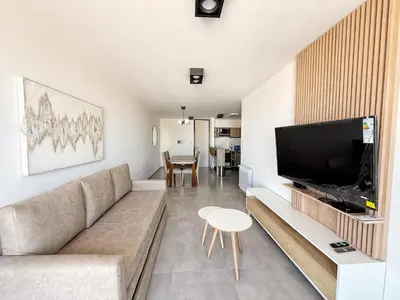 a living room with a couch and a flat screen tv at Paseo Cibeles in Villa Carlos Paz