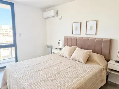 a bedroom with a large bed and a window at Paseo Cibeles in Villa Carlos Paz