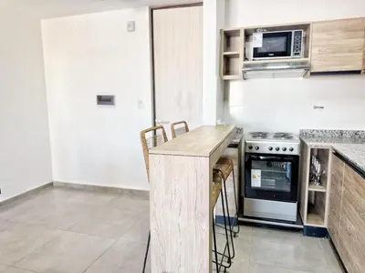 a kitchen with a counter with a stove and a microwave at Paseo Cibeles in Villa Carlos Paz
