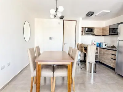 a kitchen and dining room with a wooden table and chairs at Paseo Cibeles in Villa Carlos Paz