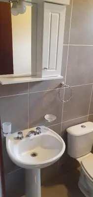 a bathroom with a white sink and a toilet at Complejo Canto de los Pájaros in Villa Parque Siquiman