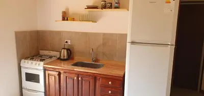 a kitchen with a sink and a white refrigerator at Complejo Canto de los Pájaros in Villa Parque Siquiman