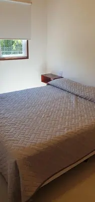 a large bed in a bedroom with a window at Complejo Canto de los Pájaros in Villa Parque Siquiman