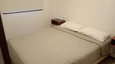 a bedroom with a white bed with a pillow at Complejo Canto de los Pájaros in Villa Parque Siquiman
