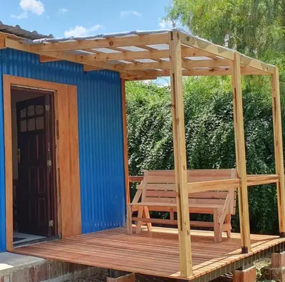 a wooden deck with a bench on a house at Complejo Canto de los Pájaros in Villa Parque Siquiman