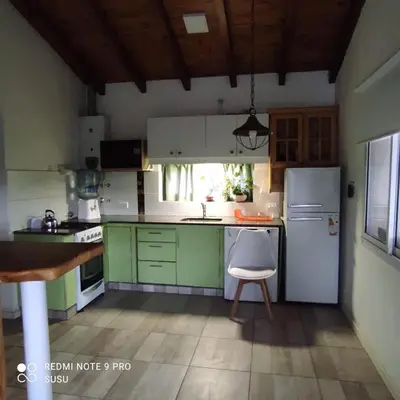 a kitchen with green cabinets and a white refrigerator at Casa El ALto 1 in Villa General Belgrano