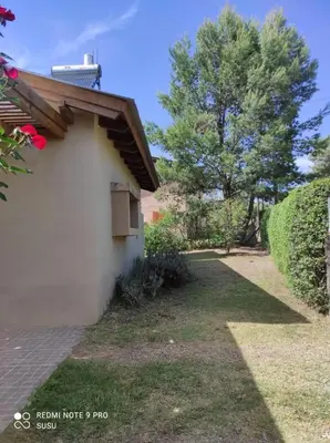 a white building with a window on the side of it at Casa El ALto 1 in Villa General Belgrano