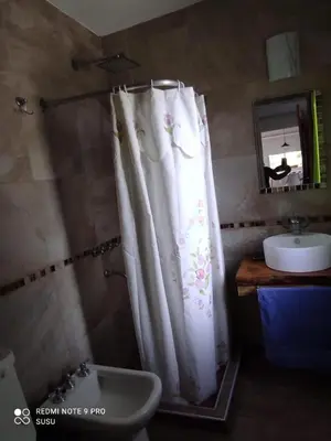 a bathroom with a shower curtain and a sink at Casa El ALto 1 in Villa General Belgrano