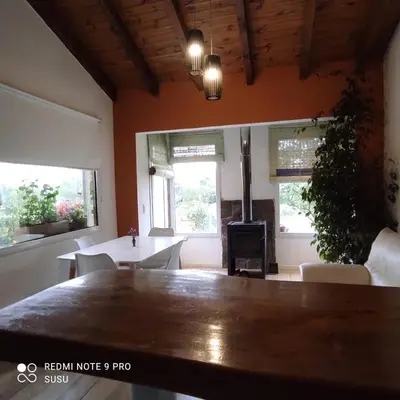 a living room with a table and a fireplace at Casa El ALto 1 in Villa General Belgrano