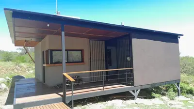 a tiny house with a porch and a deck at Puesto Kupuka in Villa de Las Rosas