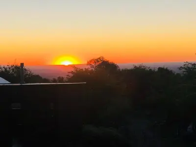 a sunset with the sun setting in the distance at Puesto Kupuka in Villa de Las Rosas
