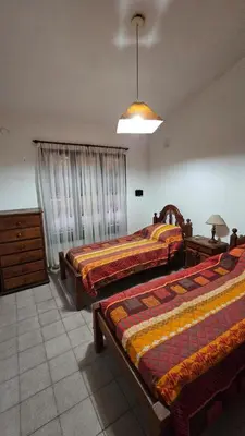 a bedroom with two beds and a pendant light at Perla de Punilla in Villa Carlos Paz