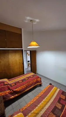 a room with two beds and a hanging light at Perla de Punilla in Villa Carlos Paz