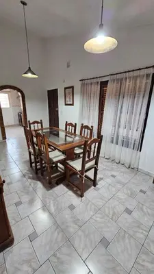 a dining room with a wooden table and chairs at Perla de Punilla in Villa Carlos Paz