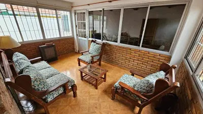 a living room with chairs and a brick wall at Perla de Punilla in Villa Carlos Paz