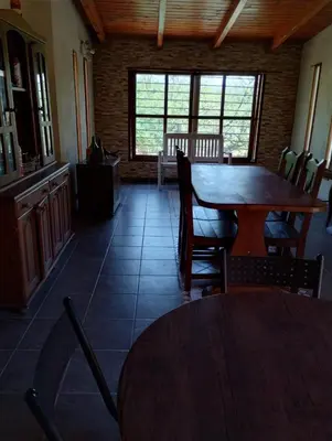 a dining room with a wooden table and chairs at La Calandria in Villa Serranita