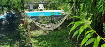 two chairs and a hammock in a garden at Las Tacuaras in Arroyo de Los Patos