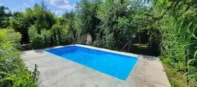 a swimming pool in a garden with trees at Las Tacuaras in Arroyo de Los Patos