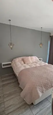 a bedroom with a bed with two lights on the wall at Cabaña La Reserva in San Roque