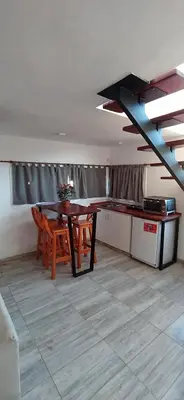 a kitchen with a table and chairs in a room at Cabaña La Reserva in San Roque