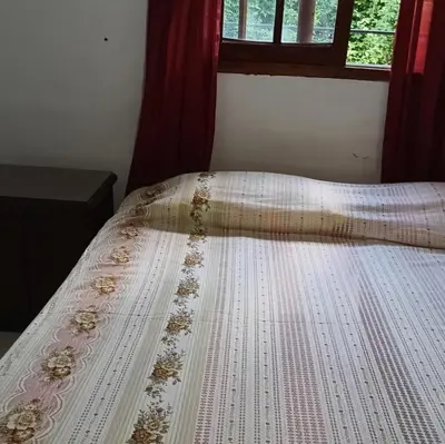 a bed with a white comforter and a window at La Calandria in Villa Serranita