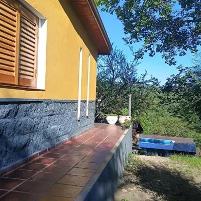 a porch of a house with two cats sitting on it at La Calandria in Villa Serranita