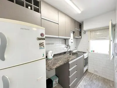 a white kitchen with a sink and a refrigerator at departamento temporal 3 personas in Cordoba