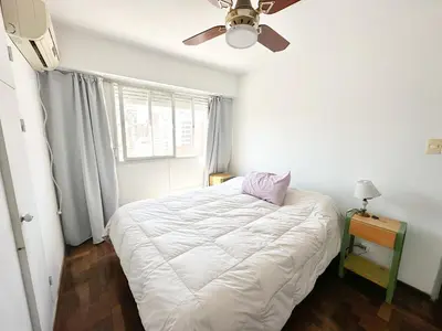 a bedroom with a white bed and a ceiling fan at departamento temporal 3 personas in Cordoba