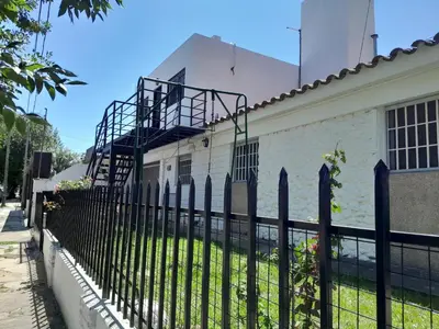 a black fence in front of a white house at Fabiana Torres in Villa Carlos Paz