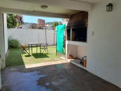a patio with a table and a chair in a yard at Fabiana Torres in Villa Carlos Paz