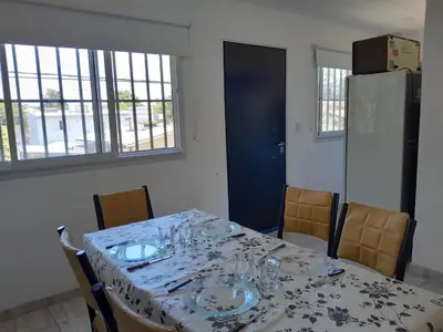 a dining room table with plates and glasses on it at Fabiana Torres in Villa Carlos Paz