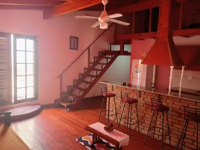 a living room with a staircase and stools at Departamento Villa Dolores in San Javier