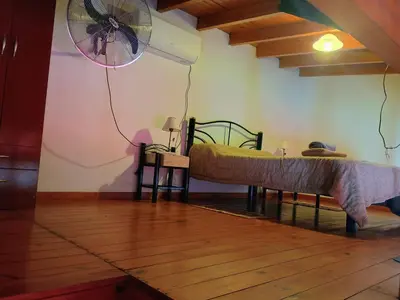 a room with a bed and a fan on the wall at Departamento Villa Dolores in San Javier