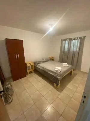 a bedroom with a bed and a cabinet in it at Complejo los lirios in Villa Los Aromos