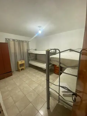 a bedroom with two bunk beds in a room at Complejo los lirios in Villa Los Aromos