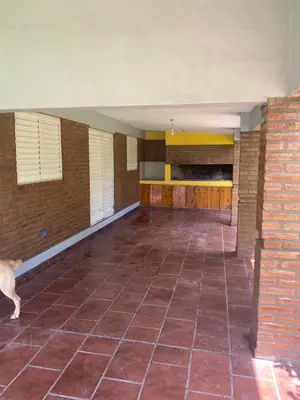a room with a brick wall and a dog standing in it at Complejo los lirios in Villa Los Aromos