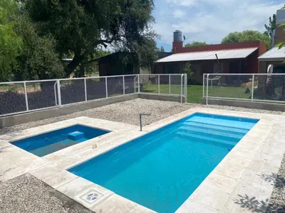 a swimming pool in a yard next to a fence at Complejo los lirios in Villa Los Aromos