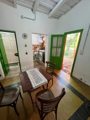 a dining room with a table and chairs and green doors at Bendecida Depto in La Paz