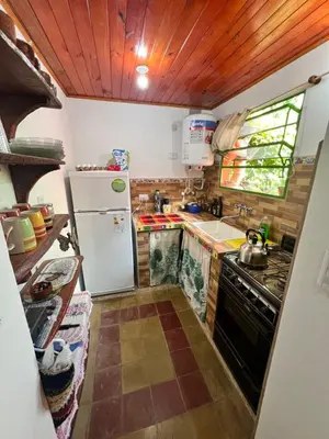 a small kitchen with a refrigerator and a sink at Bendecida Depto in La Paz