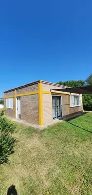 a small brick building with a large grass yard at Casa Martina in Villa Rumipal