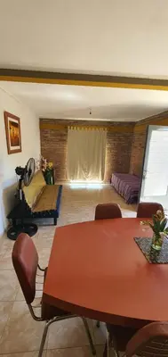 a dining room with a table and a couch in a room at Casa Martina in Villa Rumipal