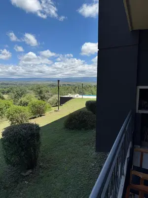 a balcony of a house with a view of a yard at Departamento Lago Los Molinos in Villa Ciudad de America