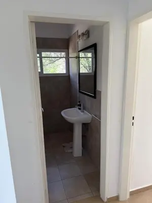 a bathroom with a sink and a mirror at Departamento Lago Los Molinos in Villa Ciudad de America