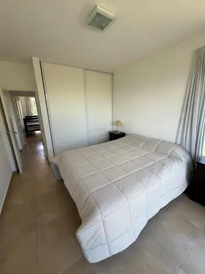 a bedroom with a large white bed in a room at Departamento Lago Los Molinos in Villa Ciudad de America