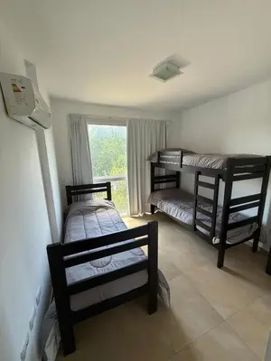 a room with three bunk beds and a window at Departamento Lago Los Molinos in Villa Ciudad de America